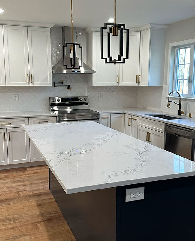 New kitchen with marble kitchen island, white cabinets and white ceramic backsplash on the walls built by HCA Construction