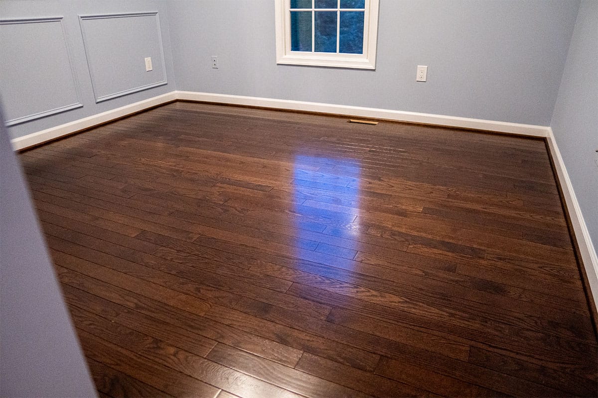 Wide view of wooden flooring installed in a guest bedroom in Derwood, MD